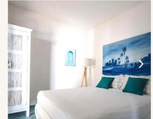 1 dormitorio blanco con 1 cama blanca grande con almohadas verdes en Villa Ginkò 10 posti Letto Torre Lapillo Resort 900 Mt dal Mare, en Torre Lapillo