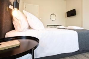 sypialnia z białym łóżkiem i stołem w obiekcie Aellō luxury apartments w mieście Markopoulo Mesogaias
