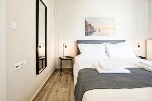 sypialnia z dużym łóżkiem z białymi poduszkami w obiekcie Aellō luxury apartments w mieście Markopoulo Mesogaias