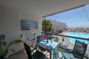 uma varanda com uma mesa e vista para uma piscina em Calypso em Cotillo