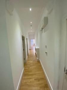 a hallway with white walls and a wooden floor at Designer Apartment APT6 in Wolverhampton