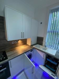 una cocina vacía con armarios blancos y lavavajillas en Designer Apartment APT6 en Wolverhampton