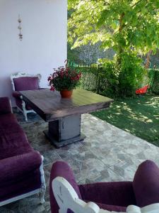 a wooden table with flowers on a patio with chairs at Hânetül Mabeyn in Rize