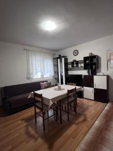 - un salon avec une table à manger et des chaises dans l'établissement Apartman Mia, à Kamenari