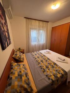 Habitación de hotel con 2 camas y ventana en Apartman Mia, en Kamenari