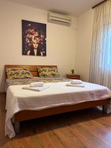 1 dormitorio con 1 cama grande y 2 toallas. en Apartman Mia, en Kamenari