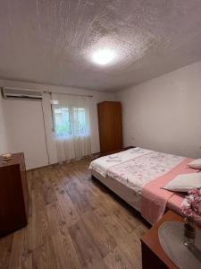 1 dormitorio con 1 cama grande y suelo de madera en Apartman Mia, en Kamenari