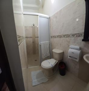 a small bathroom with a toilet and a shower at Hotel San Adolfo Carepa in Carepa
