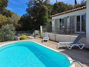 ein Haus mit einem Pool, einem Stuhl und einer Terrasse in der Unterkunft Villa K Presqu ile de Giens in Hyères