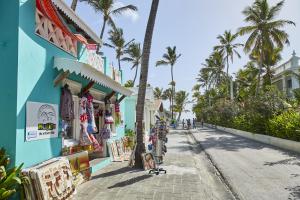 una calle frente a un edificio azul con palmeras en Riu Palace Bavaro - All Inclusive, en Punta Cana