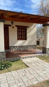 een klein huis met een veranda en een patio bij Cabañas La Suyana in Tafí del Valle