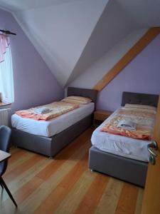 two beds in a room with a attic at Guest House Pri Treh Lipah in Ptuj