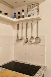 a kitchen with utensils hanging on a wall at Ti Maria Guest House in Faro