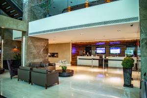a lobby of a hotel with couches and a bar at Mercure Uberlândia Plaza Shopping in Uberlândia +156 photos