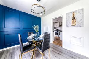 comedor con paredes azules y mesa con sillas en Contemporary 4 bedroom detached house with parking and city links, en Croydon
