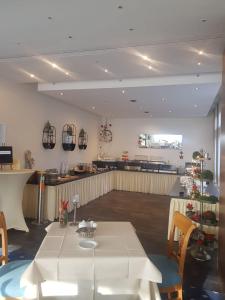 a dining room with a white table and a bar at Romantik Parkhotel am Hammerberg in Stolberg