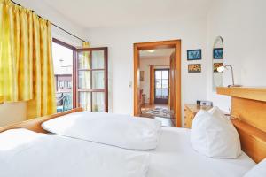 ein Schlafzimmer mit einem weißen Bett und einem Fenster in der Unterkunft Ferienwohnungen Gästehaus Licht in Reit im Winkl