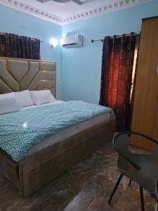 a bedroom with a bed and a table and curtains at Dazzle Apartments in Jidu