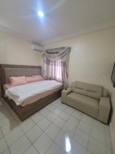 a bedroom with a bed and a couch at Dazzle Apartments in Jidu