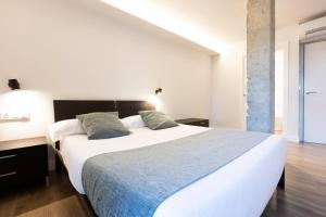 1 dormitorio con 1 cama blanca grande y 2 almohadas en Ama Guadalupekoa, en Hondarribia