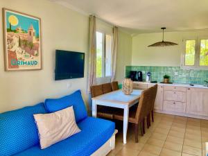 a living room with a blue couch and a table at Les Restanques 2268 glycines in Grimaud
