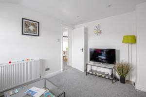 a living room with a tv and a table at Chester Stays - Beautiful loft apartment with parking in Chester