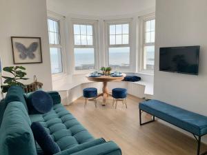 a living room with a blue couch and a table at STUNNING SEA VIEWS BEACHFRONT 2 BED in Kent