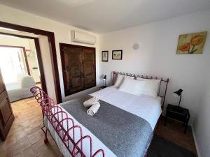 1 dormitorio con 1 cama con marco de metal rojo en See You Again Mértola - Suites do Tamejoso, en Mértola