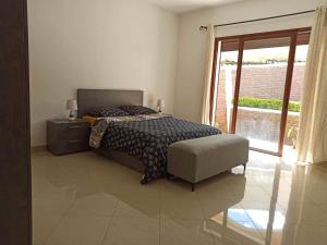 - une chambre avec un lit, une chaise et une fenêtre dans l'établissement Villa faravohitra, à Antananarivo