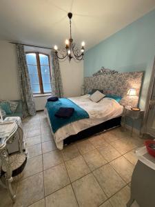 Schlafzimmer mit einem Bett und einem Kronleuchter in der Unterkunft L Ancien Moulin à Huile in Tuchan