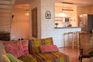 sala de estar con sofá y cocina en Duplex familial proche plage et commerces en Capbreton