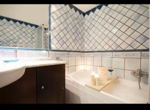 een badkamer met een wastafel en een bad met kaarsen bij B&B Residenza MALATERRA in Napels