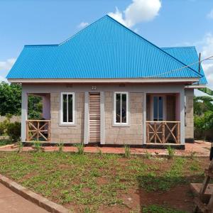 a small house with a blue roof at Kili View Lodge in Moshi