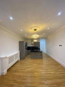 an empty room with a kitchen and a hard wood floor at Luxury Apartment APT4 in Wolverhampton