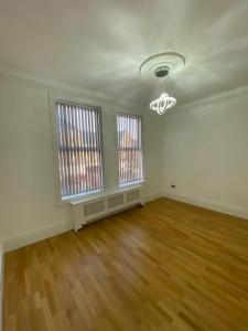 an empty living room with wooden floors and windows at Luxury Apartment APT4 in Wolverhampton