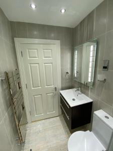 a bathroom with a white door and a sink at Luxury Apartment APT4 in Wolverhampton