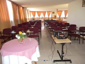a room full of tables and chairs with flowers on them at Hotel MST Colonial in Iquique