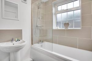 y baño blanco con lavabo, bañera y ducha. en Sleek Gem Home in Houghton le Spring, Sleeps 5, en Houghton-le-Spring