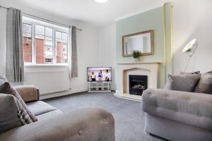 a living room with a couch and a fireplace at Sleek Gem Home in Houghton le Spring, Sleeps 5 in Houghton le Spring
