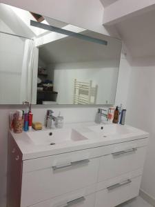 een badkamer met een wastafel en een grote spiegel bij Welcome Villa moderne belle terrasse et jardin in LʼHay-les-Roses