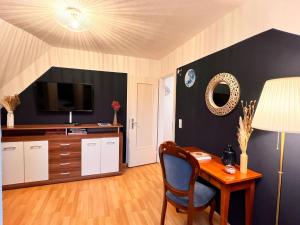 a room with a desk and a television and a table at Ferienwohnung Luna -3 Schlafzimmer, Waschmaschine, Küche, WLAN, ca 15 Min bis zum Europa Park, in Malterdingen