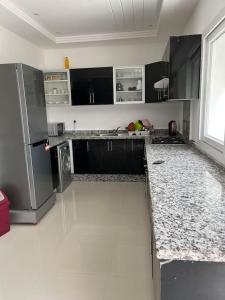 - une cuisine avec des comptoirs en noir et blanc dans l'établissement Appartement de luxe à loué Résidence Riad Saidia, à Saïdia 8 autres photos