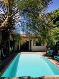 a swimming pool with a palm tree and a house at Casa Riverstone in León