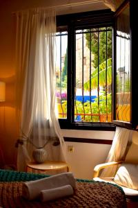 a bedroom with a bed and a large window at Carmen Art Hotel in Rhodes Town