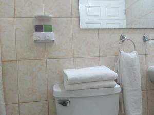 a bathroom with a pile of towels on top of a toilet at Hotel MST Colonial in Iquique