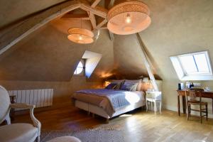 um quarto com uma cama grande num sótão em La Maison d'Horbé em La Perrière