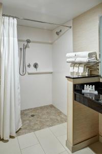 ein Bad mit einer Dusche und weißen Handtüchern in der Unterkunft Fairfield Inn & Suites by Marriott Detroit Troy in Troy