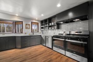 a kitchen with stainless steel appliances and black cabinets at Sessions Retreat & Hotel in Big Bear Lake