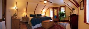 a bedroom with a bed with a blue comforter at Sawyer's Creek Bed and Breakfast in Algonquin Highlands