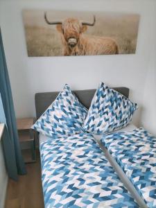 un sofá con 2 almohadas y una foto de una vaca en Ferienwohnung Luitpold 1, en Memmingen